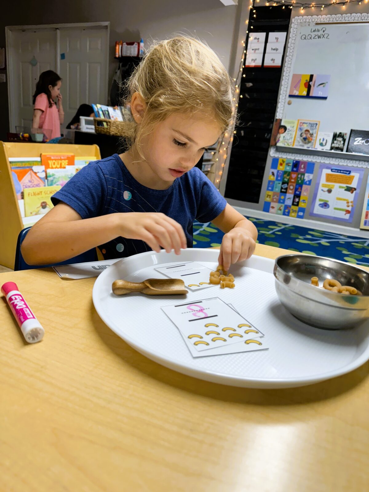 Student making sets and counting macaroni noodles.