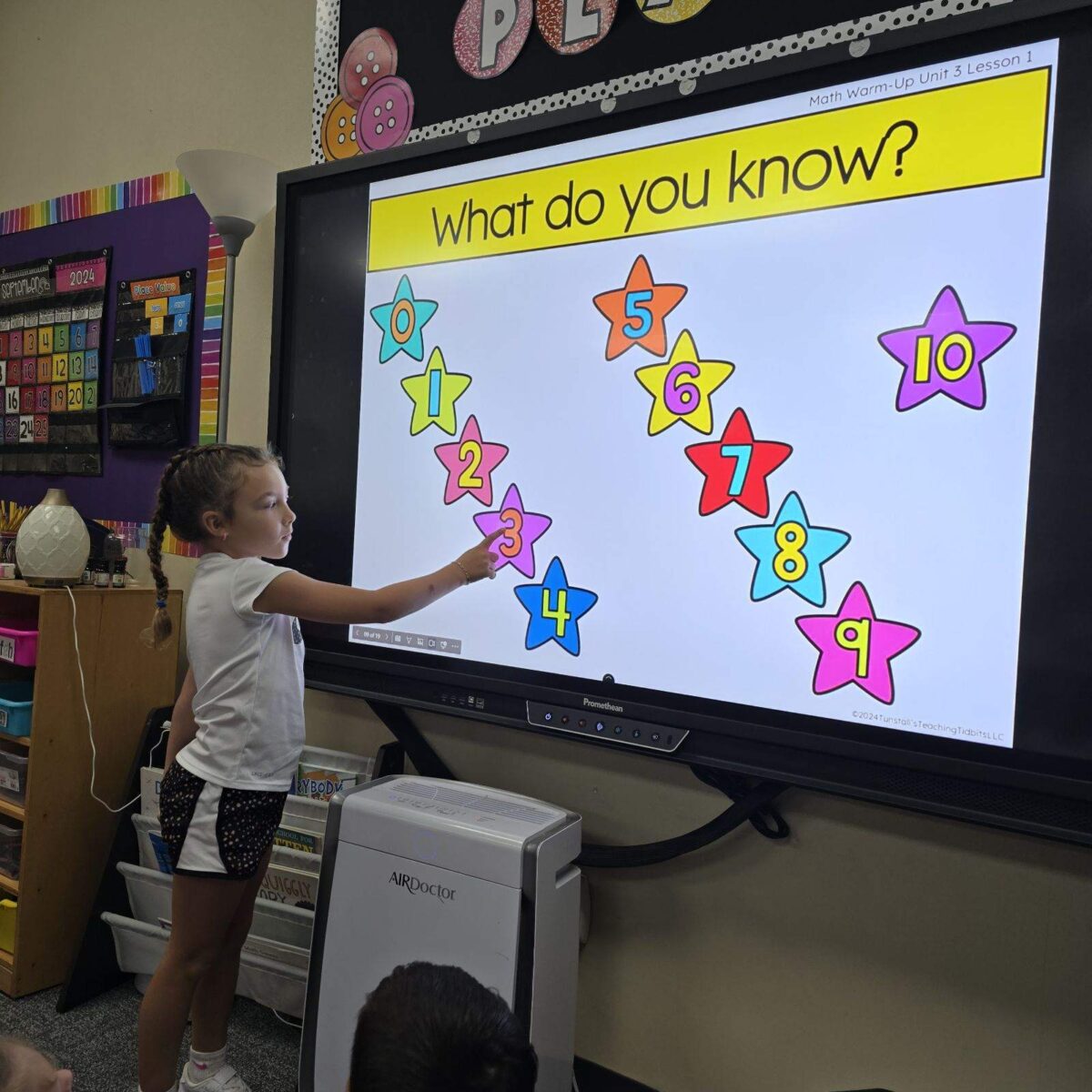 A student up at the board sharing a response to a what do you know math prompt.