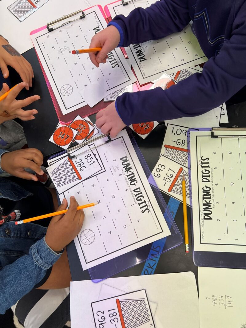 Students collaborating in small groups to solve math problems using hands-on materials